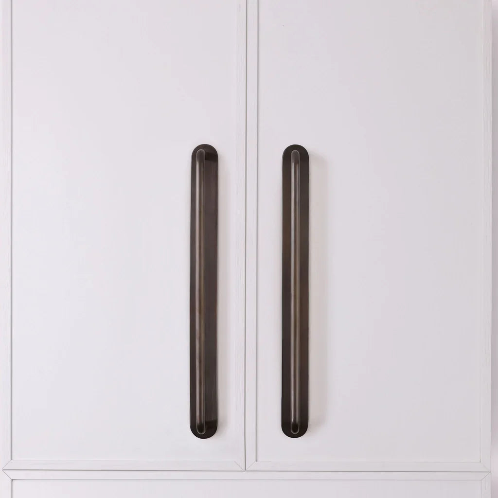 Curved Appliance Pull Backplate in antique bronze fitted to cabinetry